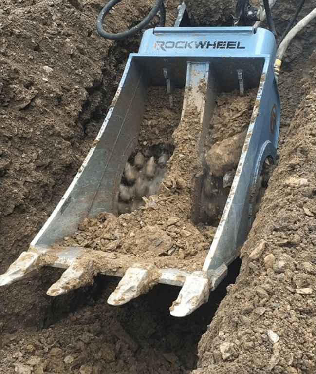 Rockwheel Cutter Bucket Breaking Up Compacted Soil In A Trench